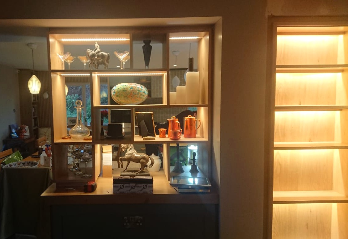 Integrated feature lighting within display shelving